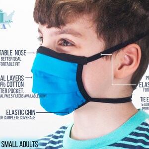 May include: A blue and black face mask with adjustable nose wire, elastic chin strap, and tie ear loops. The mask is made of 100% cotton and has a filter pocket. The text "KIDS + SMALL ADULTS" is visible at the bottom of the image.