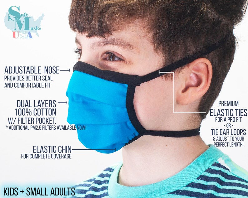 May include: A blue and black face mask with adjustable nose wire, elastic chin strap, and tie ear loops. The mask is made of 100% cotton and has a filter pocket. The text "KIDS + SMALL ADULTS" is visible at the bottom of the image.