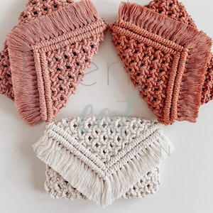 Op de afbeelding: Drie gehaakte tassen met franjes. De tassen zijn in de kleuren roze, oranje en wit.