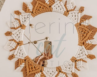 May include: A round mirror with a macrame frame in white and mustard yellow. The frame is made of woven cotton cord with fringe details.