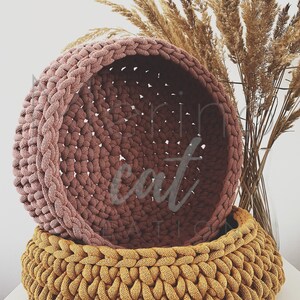 Puede incluir: Dos cestas de crochet, una de color rosa polvoriento y otra de color amarillo mostaza. Las cestas est&aacute;n apiladas una encima de la otra.