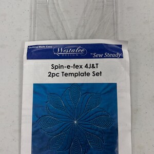 May include: A clear, plastic quilting template set with a curved design, and a paper insert. The insert features a blue floral design with the text "Spin-e-fex 4J&T 2pc Template Set" and "High Shank Template".