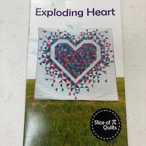 May include: A quilting pattern booklet titled "Exploding Heart" featuring a colorful quilt design with a heart shape in the center. The quilt is made of pink, blue, and white fabric. The booklet is from Slice of Pi Quilts.