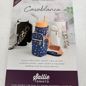 May include: A product catalog featuring a variety of water tumbler carry-alls. The catalog cover displays several tumblers in different colors and designs, including a blue floral print and a white one with a zipper pocket. Text on the cover reads "Casablanca" and "cantina 40oz water tumbler carry-all".
