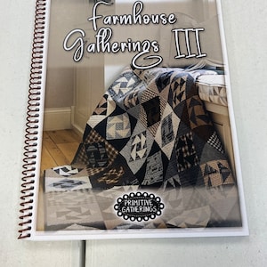 May include: A white spiral bound book with the title "Farmhouse Gatherings III" and a black and white quilt pattern on the cover. The book has a black and white circle logo that says "Primitive Gatherings".