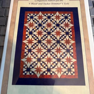May include: A quilting pattern titled "Galaxy" featuring a geometric design with red, white, and blue starbursts and square patterns. The pattern is a companion for the V Block and Tucker Trimmer I Tools. The pattern number is DTP045.