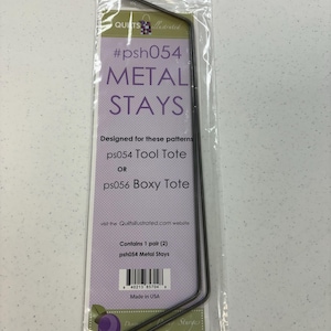 May include: A clear plastic package containing two metal stays for quilting projects. The package has a purple and white label with the text "#psh054 METAL STAYS" and "ps054 Tool Tote or ps056 Boxy Tote". The stays are dark gray with purple tips.
