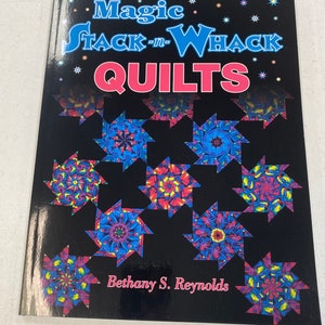 May include: Book cover with a black background and colorful star-shaped quilt blocks. The title is "Magic Stack-n-Whack Quilts" in pink and white lettering. The author's name, "Bethany S. Reynolds", is printed in pink at the bottom of the cover.