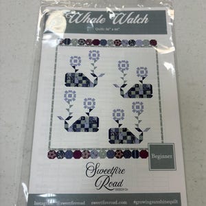 May include: A quilting pattern for a whale watch quilt. The pattern features four whales with flowers, and is labeled "Beginner". The pattern is from Sweetfire Road Design Co. and measures 56 inches by 66 inches.