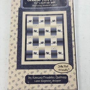 May include: A quilt pattern titled "Choose Happiness" featuring a lap quilt design. The pattern includes a quilt design with blue and beige blocks, and bird motifs. The quilt measures 72" x 84". The pattern is "Jelly Roll Friendly".