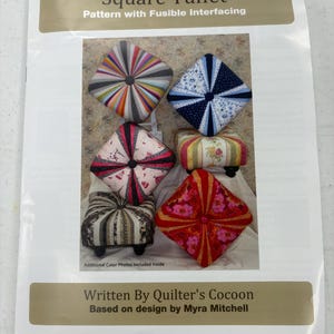 May include: A Square Tuffet pattern with fusible interfacing instruction booklet written by Quilter's Cocoon based on a design by Myra Mitchell. The cover features five square, tufted cushions in various colorful fabric patterns and designs.