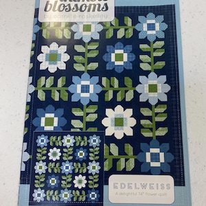 May include: A quilt pattern booklet featuring a blue and green floral design with the title "thimble blossoms" by camille roskelley and the name of the pattern "Edelweiss" with the description "A delightful 74" flower quilt".