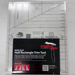 May include: A clear, non-slip Half Rectangle Trim Tool by Creative Grids. The tool is designed to make seven different sizes of half rectangles. The package includes a black label with the product name, logo, and instructions. Made in the USA.