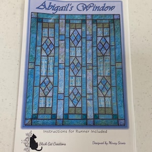 May include: A pattern for a quilt titled "Abigail's Window" with a stained glass design in shades of blue and green. The pattern includes instructions for a runner and is designed by Minay Sirois. The Black Cat Creations logo is also visible.