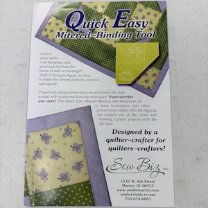 May include: An advertisement for the Quick Easy Mitered-Binding Tool. The ad features a quilt design with the tool's name in large, stylized text. The text describes the tool's benefits for quilters and crafters.