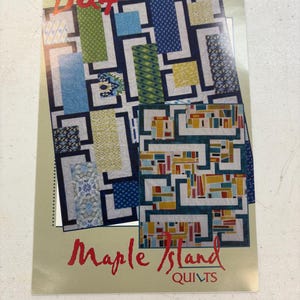 May include: A quilt pattern booklet with the title "Maple Island Quilts" and the number "BQ4" on the cover. The cover features a colourful quilt design with geometric shapes in shades of blue, green, yellow, and red.
