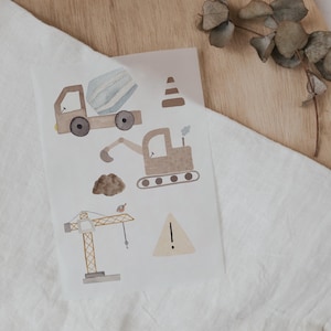 Könnte beinhalten: Ein Set mit Aufklebern von Baufahrzeugen mit einem Betonmischer, einem Bagger, einem Kran und Verkehrskegeln. Die Aufkleber sind im Aquarell-Stil mit braunen, beigefarbenen und gelben Tönen illustriert.