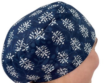 May include: A navy blue cap with a white floral pattern. The cap is made of fabric and is designed to cover the head. The floral design is repeated across the surface of the cap.