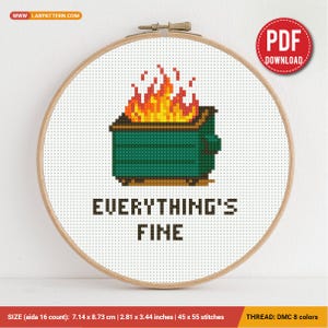 May include: Cross-stitch hoop featuring a green dumpster on fire with the phrase "EVERYTHING'S FINE" stitched in black. The design includes a red and yellow flame. The hoop measures 2.81 x 3.44 inches.