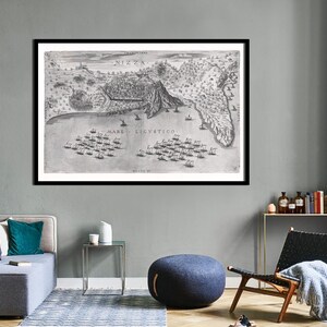 May include: A black and white framed print of an old map of a coastal city. The map is titled 'NIZZA' and shows the city surrounded by water with ships in the bay. The text 'MARE LIGURTICO' is written on the map.