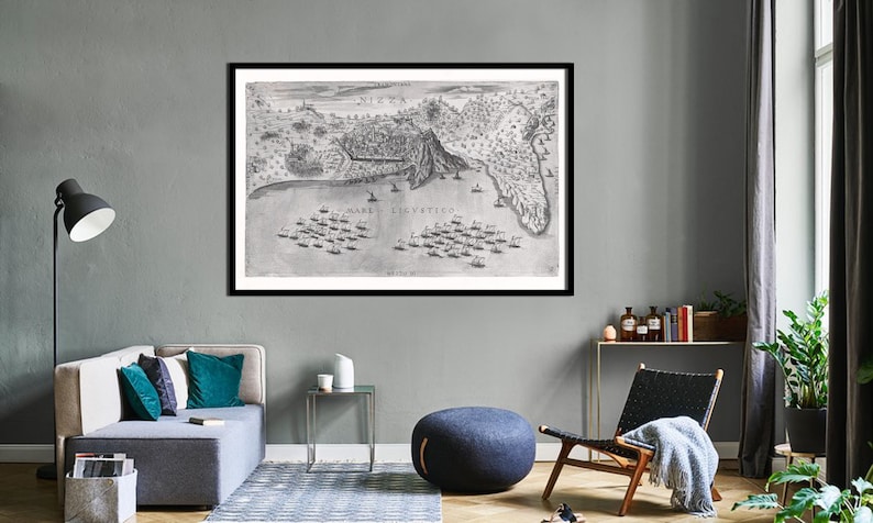 May include: A black and white framed print of an old map of a coastal city. The map is titled 'NIZZA' and shows the city surrounded by water with ships in the bay. The text 'MARE LIGURTICO' is written on the map.