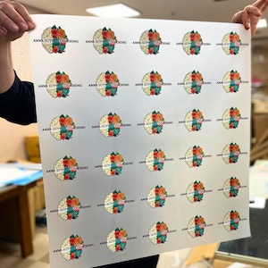 May include: A sheet of stickers featuring a brain design with floral accents in orange, red, and teal. The text "ANNA SUTTON COACHING" is printed above each brain graphic. The stickers are arranged in a grid pattern.