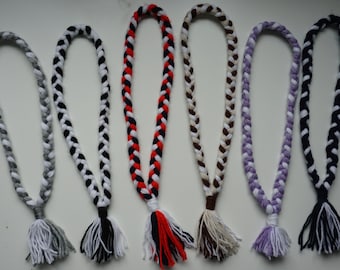 Puede incluir: Seis cordones trenzados con borlas en varios colores, incluyendo gris, negro, blanco, rojo, marrón y morado.