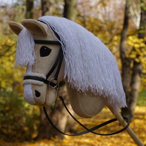 Hobby horse palomino with black bridle./ Hobby horse Isabella with a black bridle.