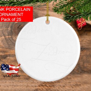Peut inclure: Ornement en porcelaine blanc, rond et vierge, avec une ficelle dor&eacute;e pour l'accrocher. La surface de l'ornement est lisse. Le texte sur l'image indique "BLANK PORCELAIN ORNAMENT Pack of 25". Le fond comprend des d&eacute;corations de No&euml;l et une surface en bois.
