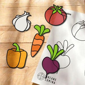 May include: A set of colorful vegetable-shaped enamel pins including a white garlic bulb, an orange carrot with green tops, a yellow bell pepper, and a red tomato. A white paper sheet labeled Veggies Pattern by Arcane Lumina shows outlines.