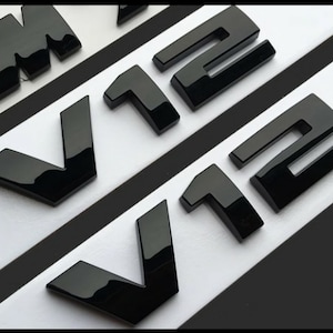 2x BMW V12 emblem, glossy black, new in foil, lettering