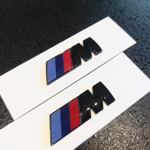 2x BMW M emblem, 45 x 15 mm, glossy black, new in foil, lettering... BMW 3 series, 5 series, 1 series, 2 series, 6 series, 7 series, M1, M2, M3, M4, M5, M6, M8.. .