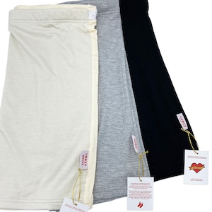 May include: Three pairs of long, soft, stretchy, cotton leggings in ivory, gray, and black. Each pair has a tag that says "The Cozy Warrior" with a red heart logo.