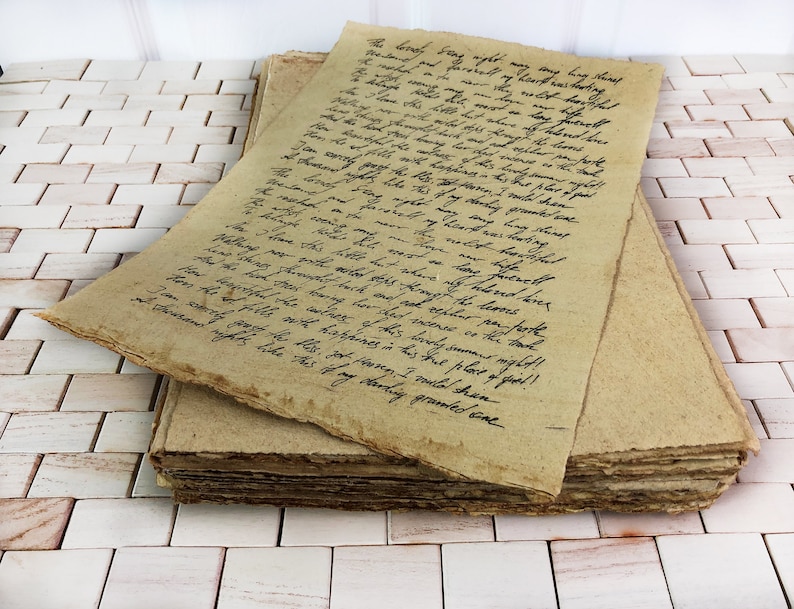 May include: A stack of rectangular, tan-colored handmade paper sheets with rough, deckled edges. The top sheet features black handwritten cursive text in English, detailing a poetic narrative about a summer night, love, and farewells.