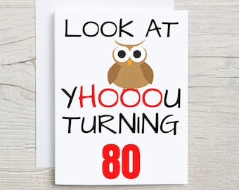 May include: A white greeting card featuring a brown owl illustration and black text that reads LOOK AT YHOOOU TURNING with the number 80 in large red font below. The card is paired with a matching white envelope.