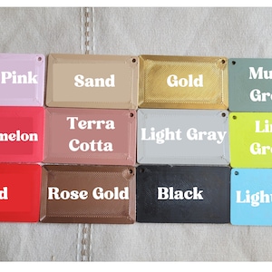 May include: A collection of 12 color swatches, each with a different color name printed on it. The colors include light pink, sand, gold, muted green, watermelon, terra cotta, light gray, lime green, red, rose gold, black, and light blue.