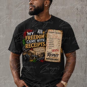 May include: A black short-sleeve t-shirt featuring a graphic print with the text My Freedom Came With Receipts, a Freedom Receipt listing sacrifice, strength, resilience, excellence, and legacy, and imagery of Black Wall Street and chains.