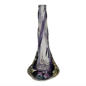 May include: A clear glass vase with a twisted design. The vase features swirling purple and white accents throughout its elongated shape. The base is wider, with a rounded, bulbous form, and the top narrows to a small opening.