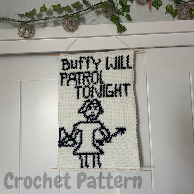 May include: White crochet wall hanging with black text that reads "Buffy Will Patrol Tonight" and a black and white pixelated image of a woman with a stake.