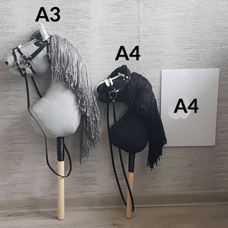 May include: Two toy rocking horses, one gray and one black, with wooden sticks and reins. The gray horse has the text "A3" above it and the black horse has the text "A4" above it. A white sign with the text "A4" is in the background.