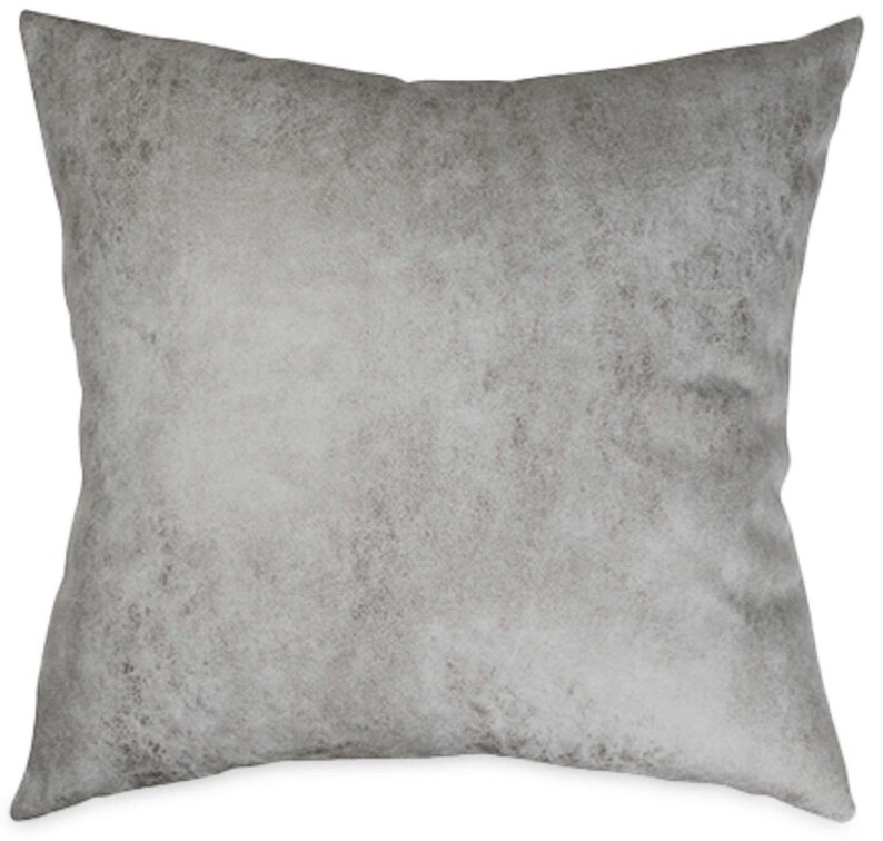 May include: A square decorative pillow with a textured, mottled gray pattern. The pillow has a soft, neutral color palette, with variations of light and dark gray. The pillow is designed for home decor.