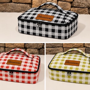 May include: Three rectangular lunch bags with a plaid pattern in black and white, red and white, and green and white. Each bag features a top handle, a zippered closure, and a brown leather-like patch on the lid with the name Munson embossed.