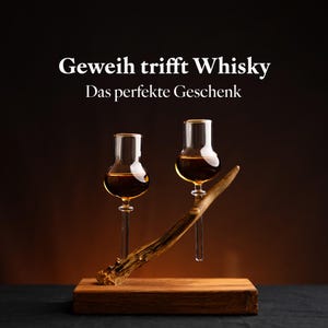 May include: Two small glasses of whiskey on a wooden base with a decorative antler. The text "Geweih trifft Whisky" and "Das perfekte Geschenk" is displayed above the glasses.