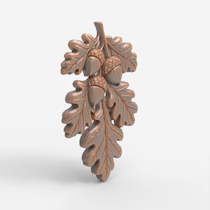May include: A bronze-coloured oak leaf and acorn decorative element. The detailed carving features three acorns and several oak leaves. The leaves have a textured surface and are arranged on a stem. The overall design is a natural, botanical theme.