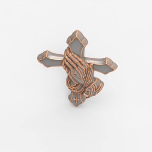 May include: A decorative wall cross featuring a dark gray finish with copper-colored edges. The center of the cross displays a relief sculpture of two hands pressed together in prayer, with a small rosary draped over the hands and a tiny cross.