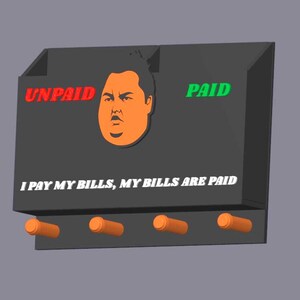 Puede incluir: Un organizador de pared negro con las palabras "UNPAID" en rojo y "PAID" en verde. Presenta una cara de dibujos animados naranja y el texto "I PAY MY BILLS, MY BILLS ARE PAID". Cuatro clavijas naranjas están debajo.