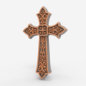 Pode incluir: Uma cruz decorativa com um design ornamentado. A cruz apresenta um padrão de filigrana de cor bronze sobre uma base cinza. O design inclui elementos florais e de rolagem, com um motivo floral central.