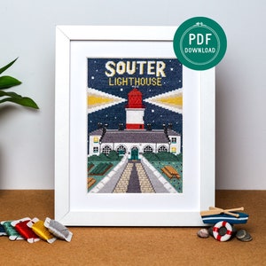 May include: A framed cross-stitch pattern of the Souter Lighthouse in Scotland. The lighthouse is red and white with a blue roof and is surrounded by a green lawn. The text "Souter Lighthouse" is above the lighthouse.