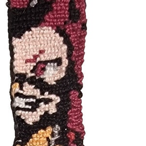 May include: Red, black, and yellow embroidered keychain with a cartoon character and the word "KIRISHIMA" in black beads.