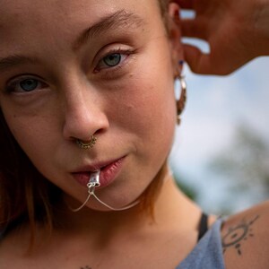 Close-up showing how the sterling silver breathing pendant is used for a long exhale.